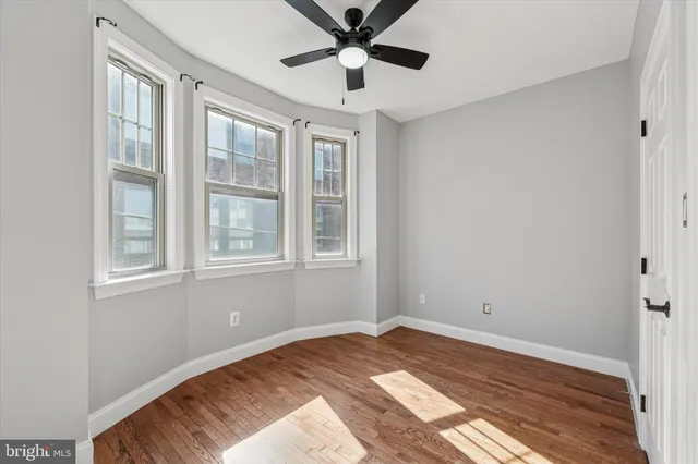 a view of a bedroom with wooden floor and windows