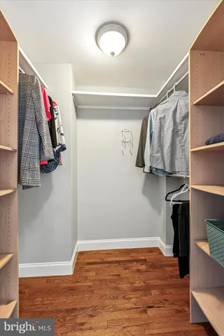 a view of walk in closet with clothes and shoes