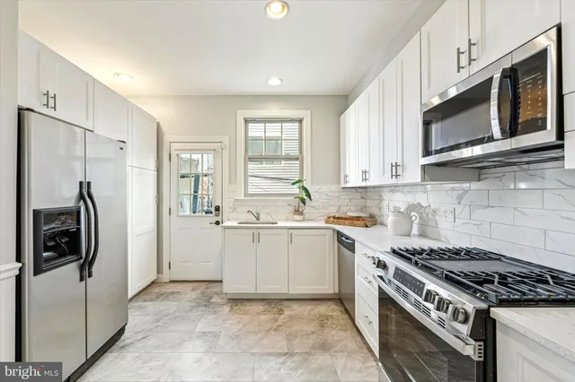 a kitchen with stainless steel appliances granite countertop a stove a refrigerator and a microwave