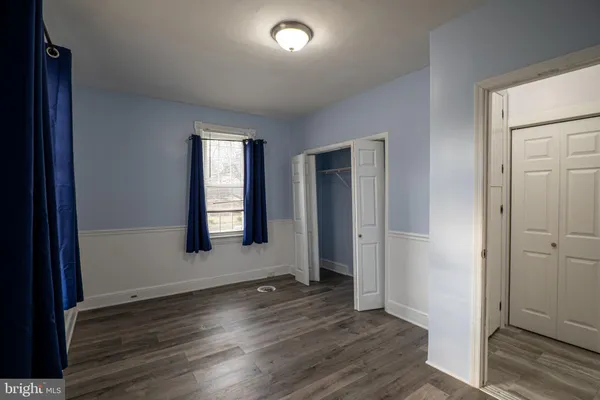 an empty room with wooden floor and a window