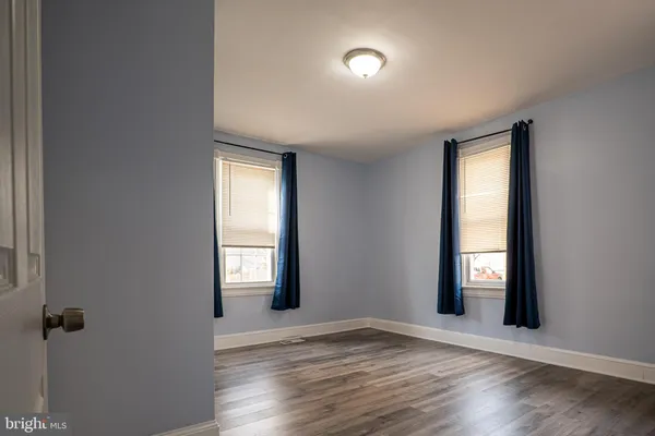 a view of a hallway with wooden floor and windows