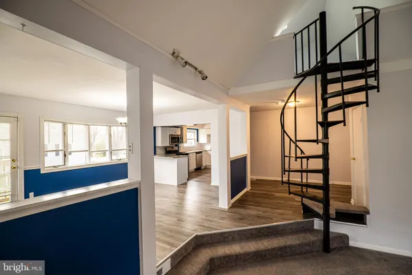 a view of a hallway with wooden floor and staircase