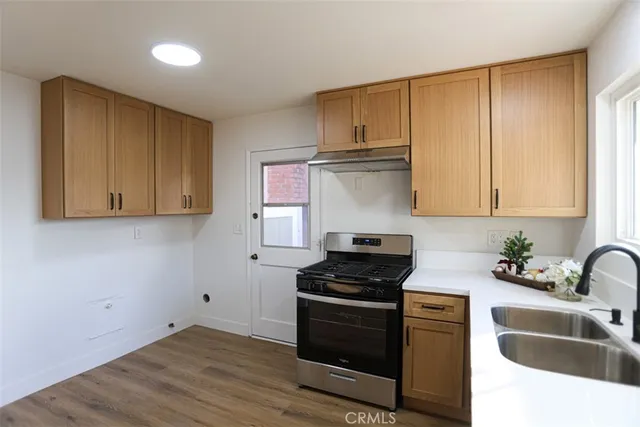 a kitchen with granite countertop a sink a stove and cabinets