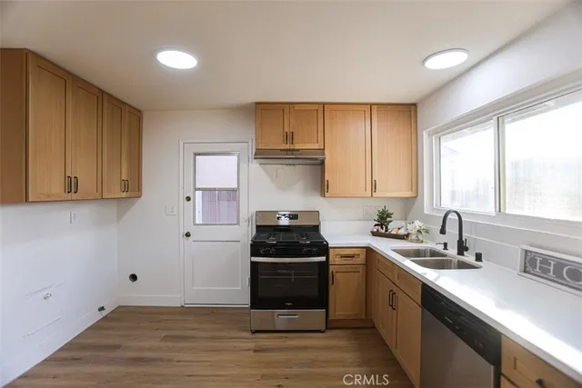 a kitchen with a sink stove top oven and cabinets