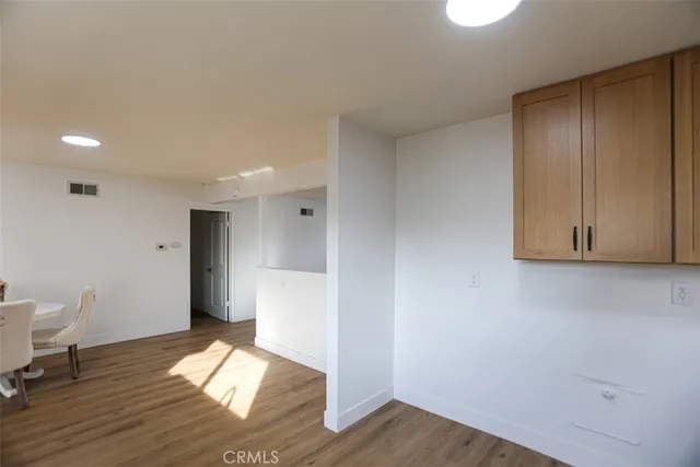 a view of empty room with wooden floor and sink