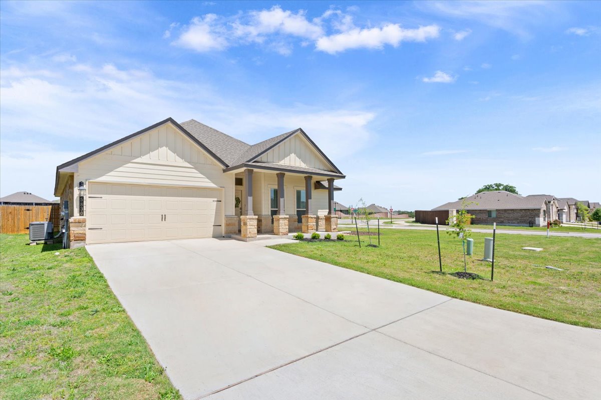 5830 Copano Road Belton, TX 76513 - Photo 2 of 34 View of front of home with concrete driveway, central air condition unit, board and batten siding, an attached garage, and a front lawn