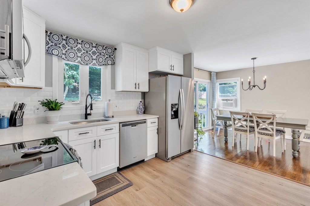 336 Taylor Road Enfield, CT 06082 - Photo 6 of 30 a kitchen with granite countertop a refrigerator a sink dishwasher a stove and white cabinets with wooden floor