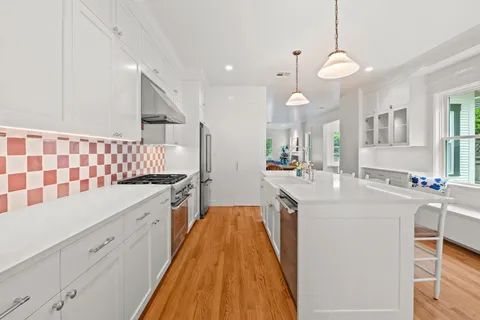 a large kitchen with kitchen island a sink a counter space and stainless steel appliances