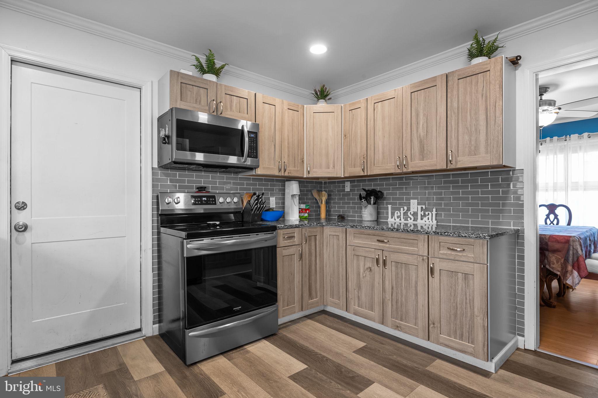 55 Rose Apple Road Levittown, PA 19056 - Photo 11 of 40 a kitchen with stainless steel appliances granite countertop a stove microwave and cabinets
