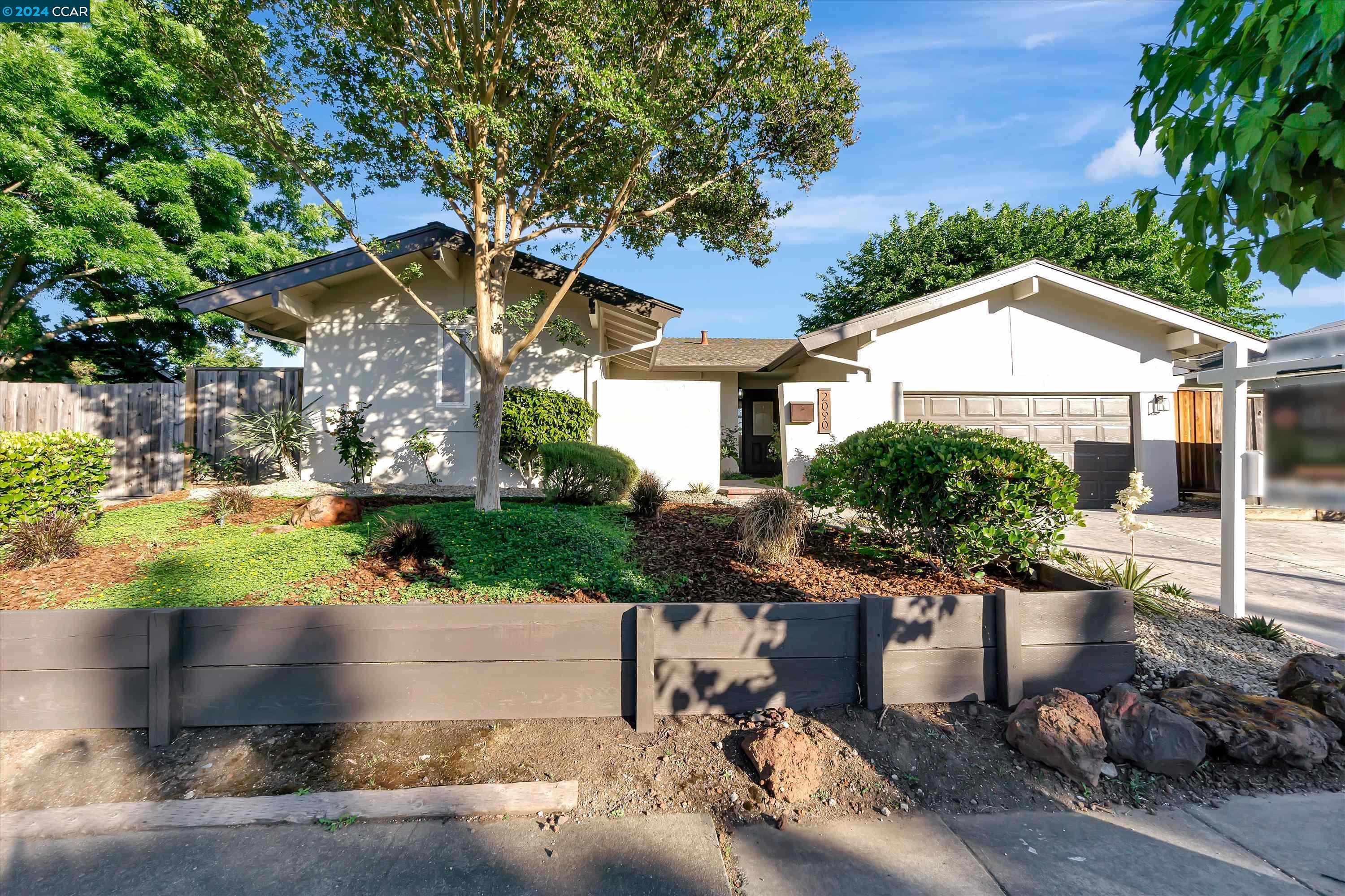 a front view of a house with a yard and a garden