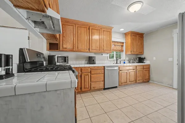 a kitchen with a sink white cabinets and white appliances