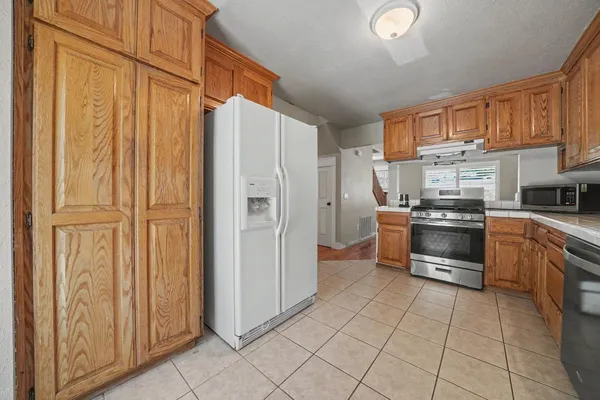 a kitchen with stainless steel appliances a refrigerator and a stove top oven