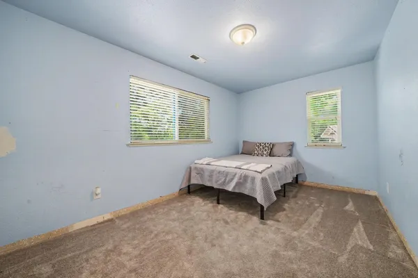 a spacious bedroom with a bed and a window