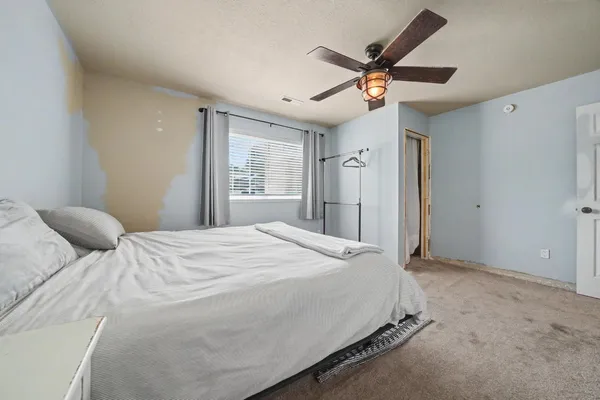 a bedroom with a large bed and a ceiling fan