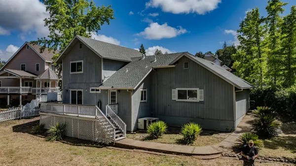 a view of a white house with large windows and a small yard