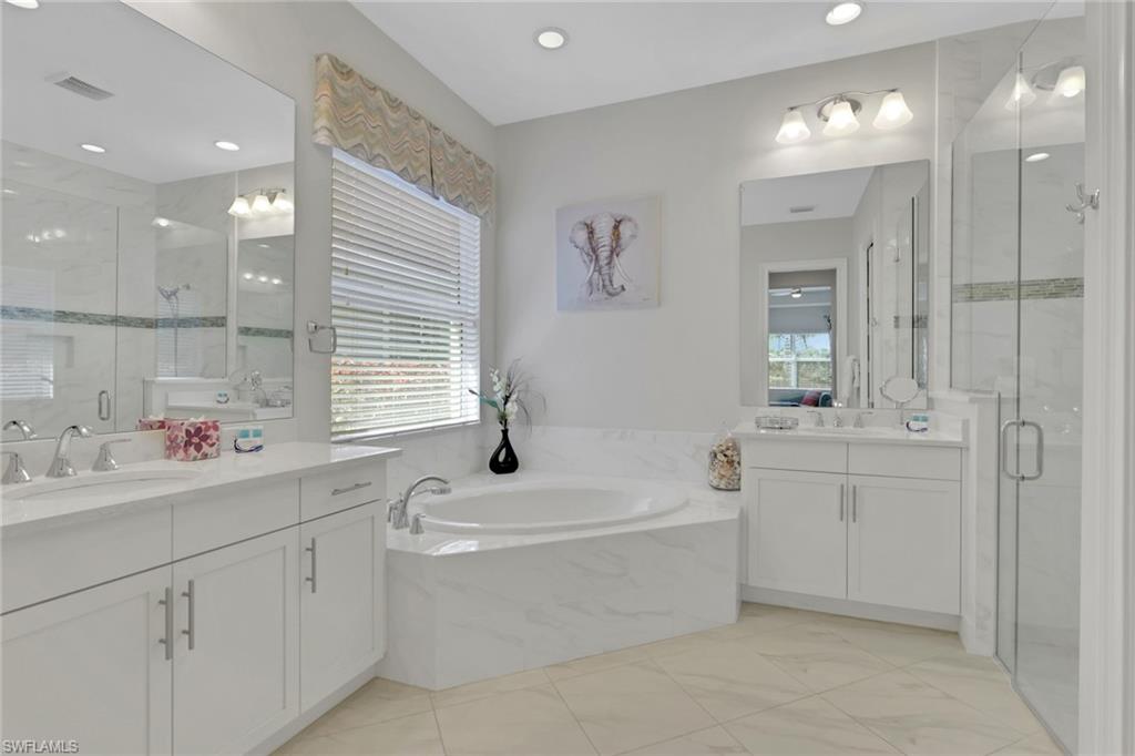 6394 Warwick Avenue Naples, FL 34113 - Photo 16 of 30 a bathroom with a sink a tub and a mirror