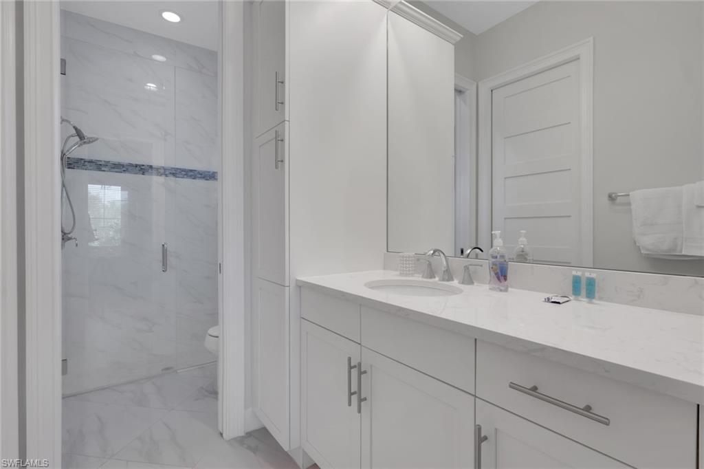 6394 Warwick Avenue Naples, FL 34113 - Photo 19 of 30 a bathroom with a sink and a mirror