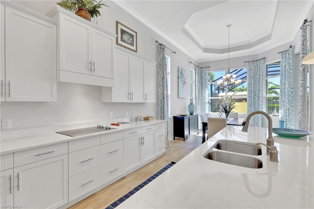 6394 Warwick Avenue Naples, FL 34113 - Photo 6 of 30 a kitchen with white cabinets a sink a window and stainless steel appliances