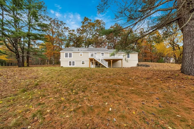 a white house that has a tree in front of it