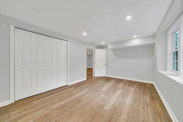a view of empty room with wooden floor and entryway
