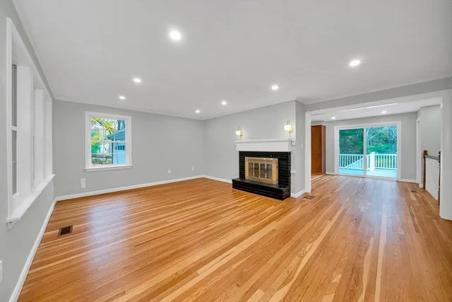 a view of empty room with wooden floor and fireplace