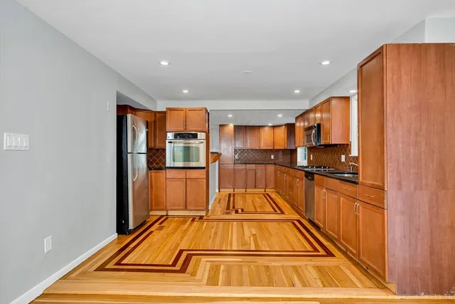 a view of kitchen with stainless steel appliances dining room and wooden floor