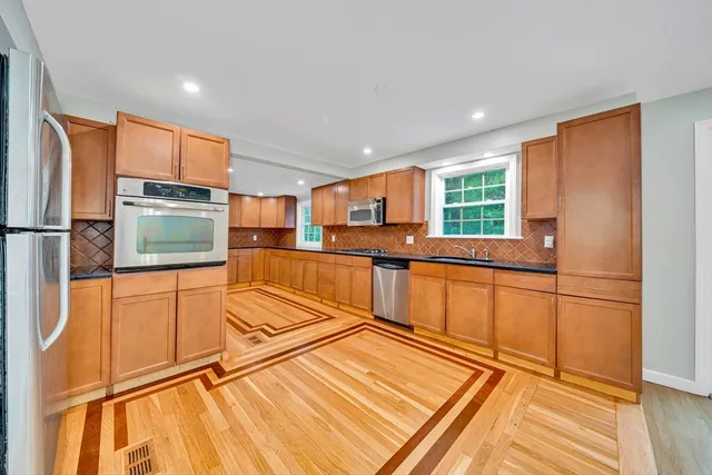a kitchen with stainless steel appliances granite countertop a refrigerator and a stove top oven