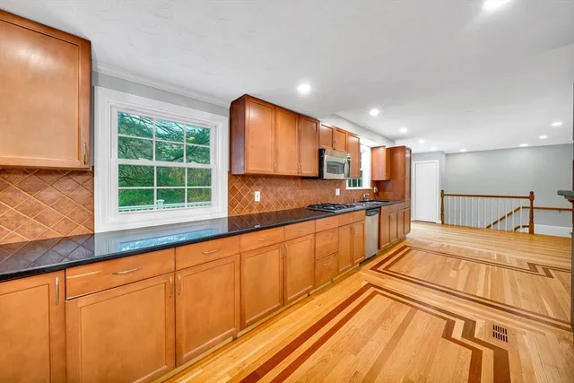 a large kitchen with kitchen island granite countertop a large window