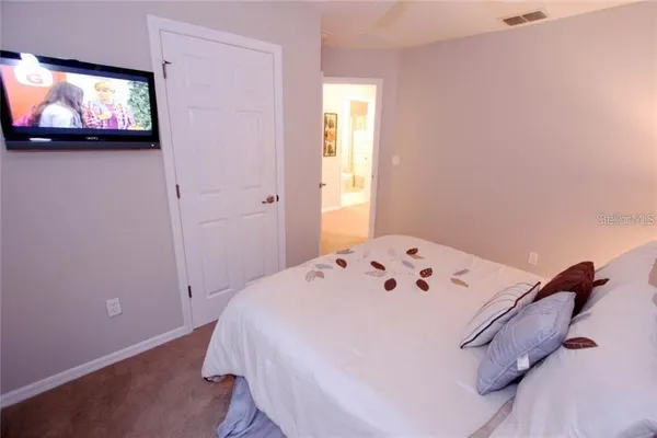 a bedroom with a bed and a flat screen tv