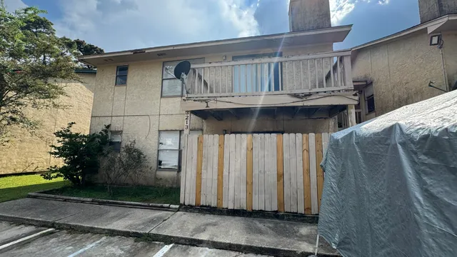 a view of a house with a wooden fence