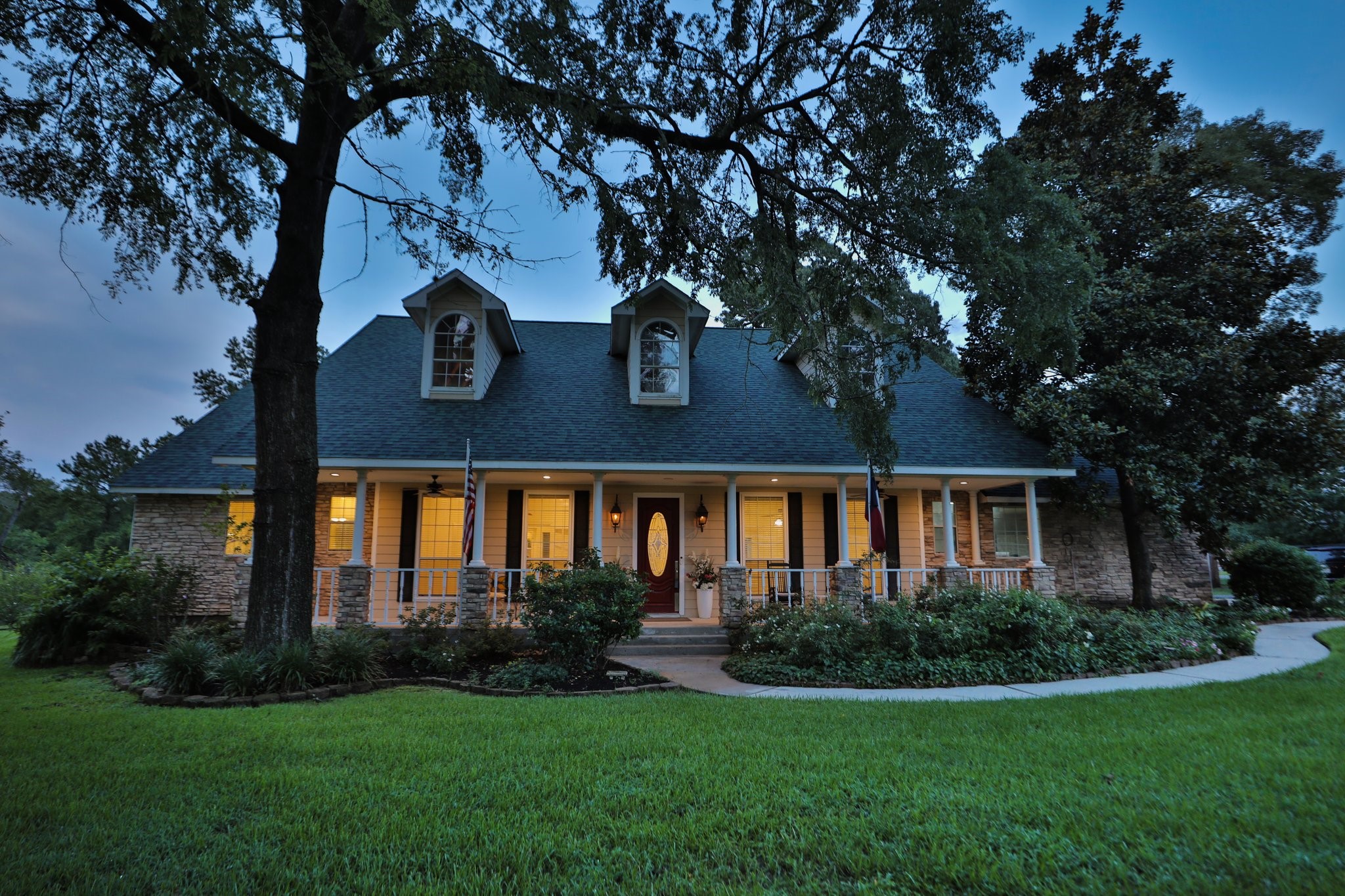 34310 High Point Drive Magnolia, TX 77355 - Photo 1 of 48 Charming, two-story home with a welcoming front porch and dormer windows. Surrounded by lush greenery and mature trees, it features a well-maintained lawn and a pathway leading to the entrance. Perfect for a cozy, inviting atmosphere.