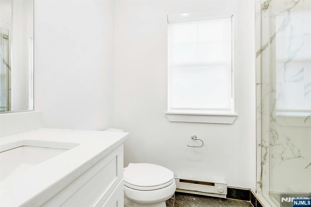 74 Clarendon Place, Unit 202 Hackensack, NJ 07601 - Photo 22 of 32 a bathroom with a sink a toilet and a window