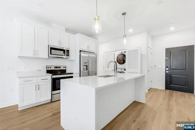 a kitchen with kitchen island a sink stainless steel appliances and cabinets