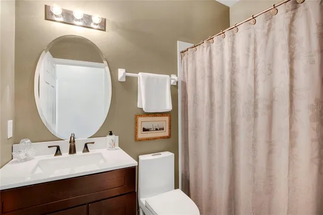 a bathroom with a sink vanity mirror and toilet