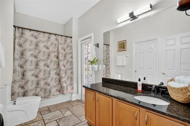 a spacious bathroom with a granite countertop sink a toilet and shower
