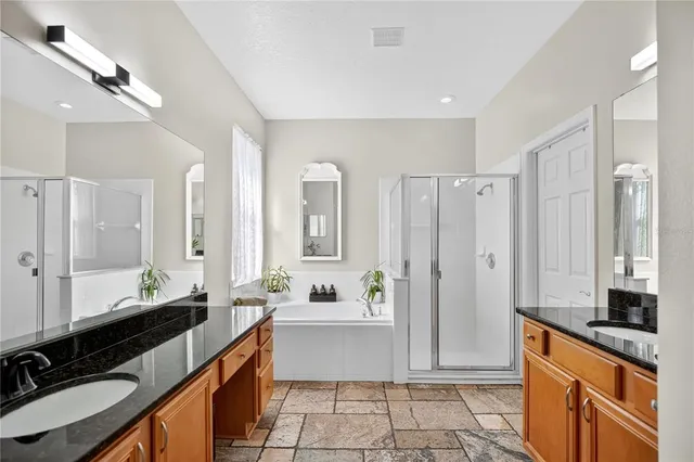 a large bathroom with a double vanity sink a mirror and a shower