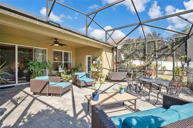 a view of a patio with couches table and chairs and potted plants