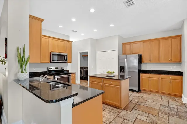 a kitchen with stainless steel appliances a sink stove and refrigerator