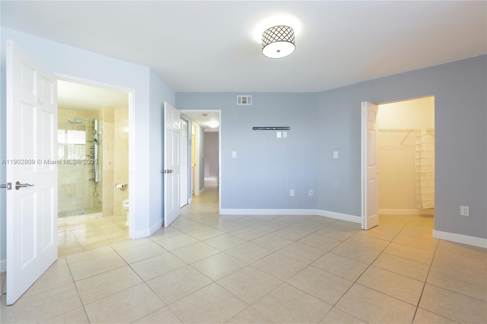 an empty room with kitchen view and bathroom view