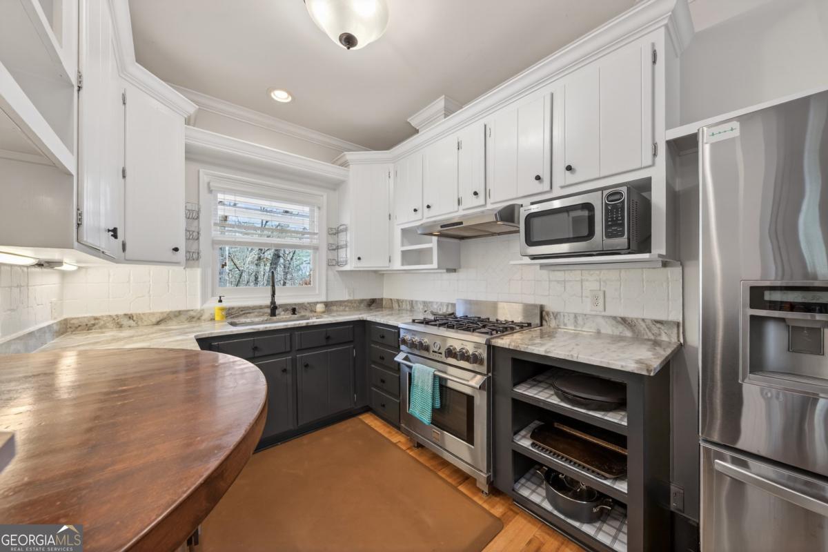 1091 Maple Ridge Way Greensboro, GA 30642 - Photo 13 of 52 a kitchen with stainless steel appliances granite countertop a stove refrigerator and cabinets