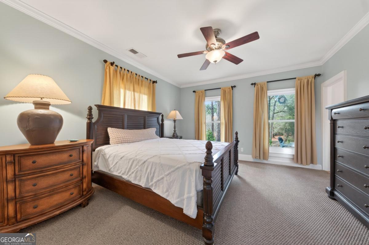 1091 Maple Ridge Way Greensboro, GA 30642 - Photo 18 of 52 a bedroom with a bed a chandelier and dresser