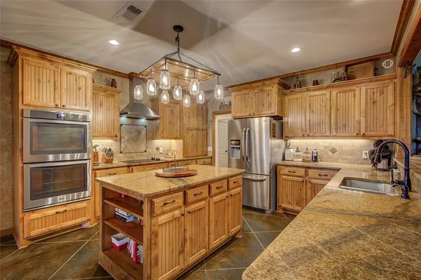 a kitchen with stainless steel appliances granite countertop a stove and a refrigerator