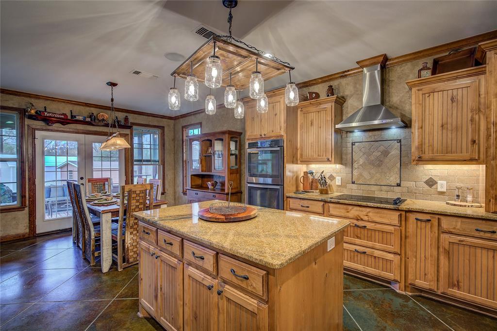 811 County Road 4250 Point, TX 75472 - Photo 20 of 38 Gourmet eat-in kitchen measuring 23’5” x 14’3”, featuring a large island, double ovens, cooktop, appliance garage, breakfast bar, and custom upgrades throughout.