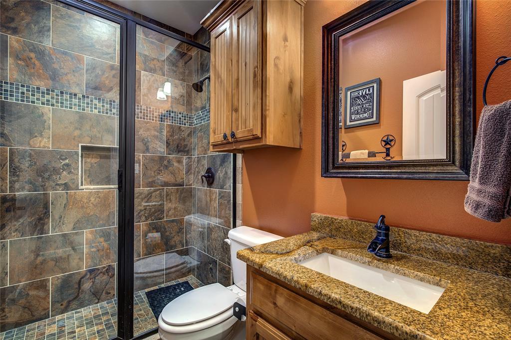 811 County Road 4250 Point, TX 75472 - Photo 22 of 38 Hall bathroom featuring abundant cabinet storage and a custom shower.