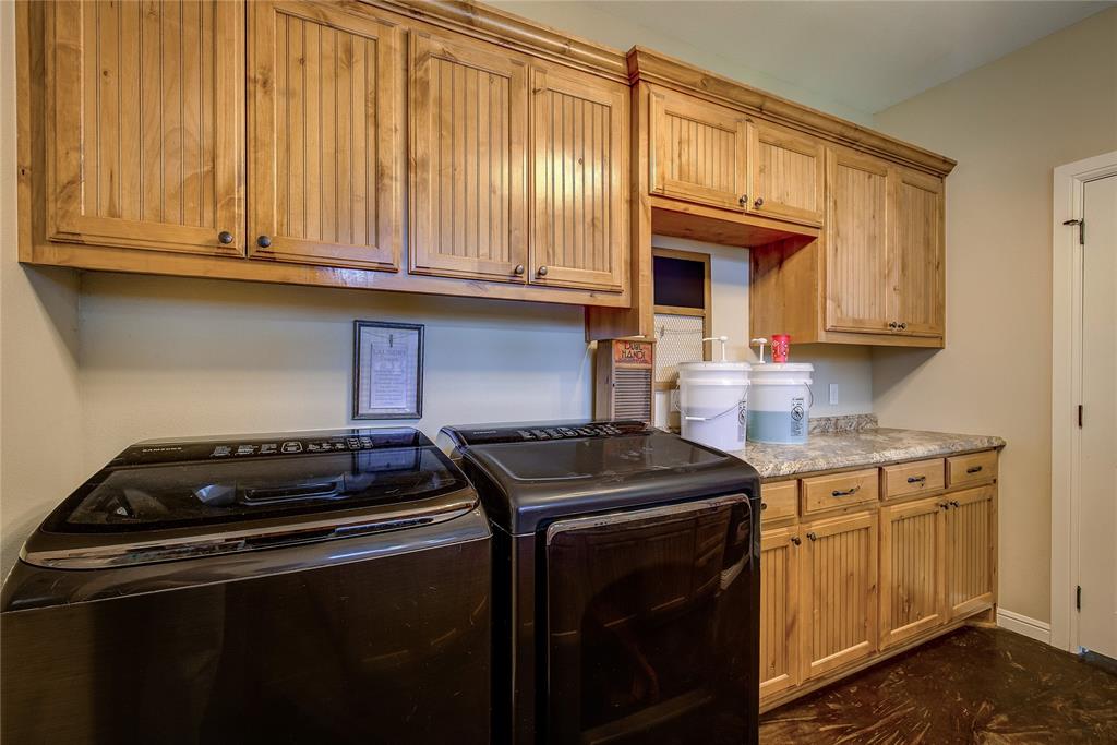 811 County Road 4250 Point, TX 75472 - Photo 30 of 38 Spacious laundry room measuring 11’7” x 8’9”, featuring a utility sink, abundant cabinet storage, and dedicated areas for hanging and folding clothes.