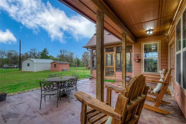 a view of a patio with a table chairs and a backyard