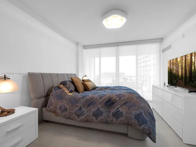 a view of a dining room and livingroom with furniture wooden floor a rug and a chandelier