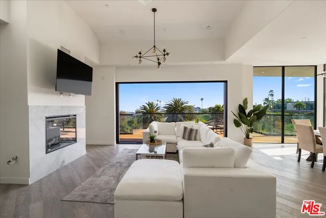 a living room with furniture a flat screen tv and a floor to ceiling window