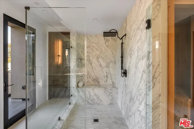 a bathroom with a granite countertop sink a mirror and shower