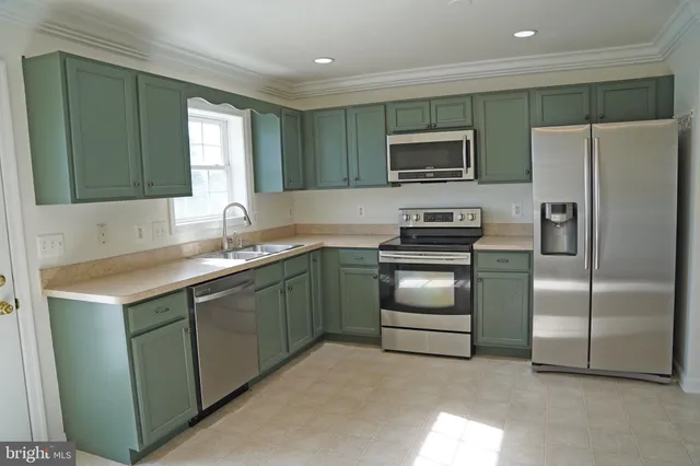 a large kitchen with a stove a sink and a refrigerator